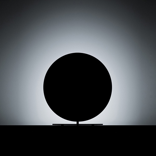 Calvino lamp shining at a white wall making it look like a total solar eclipse