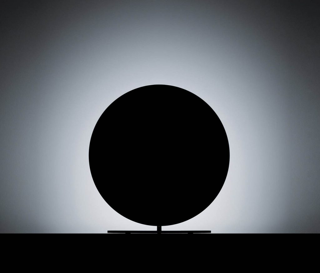 Calvino lamp shining at a white wall making it look like a total solar eclipse