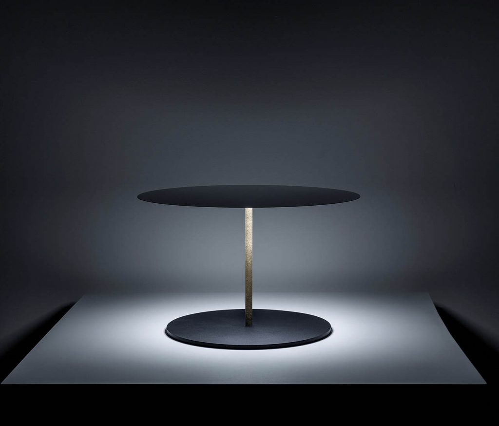 Calvino lamp illuminating a white table in a dark room