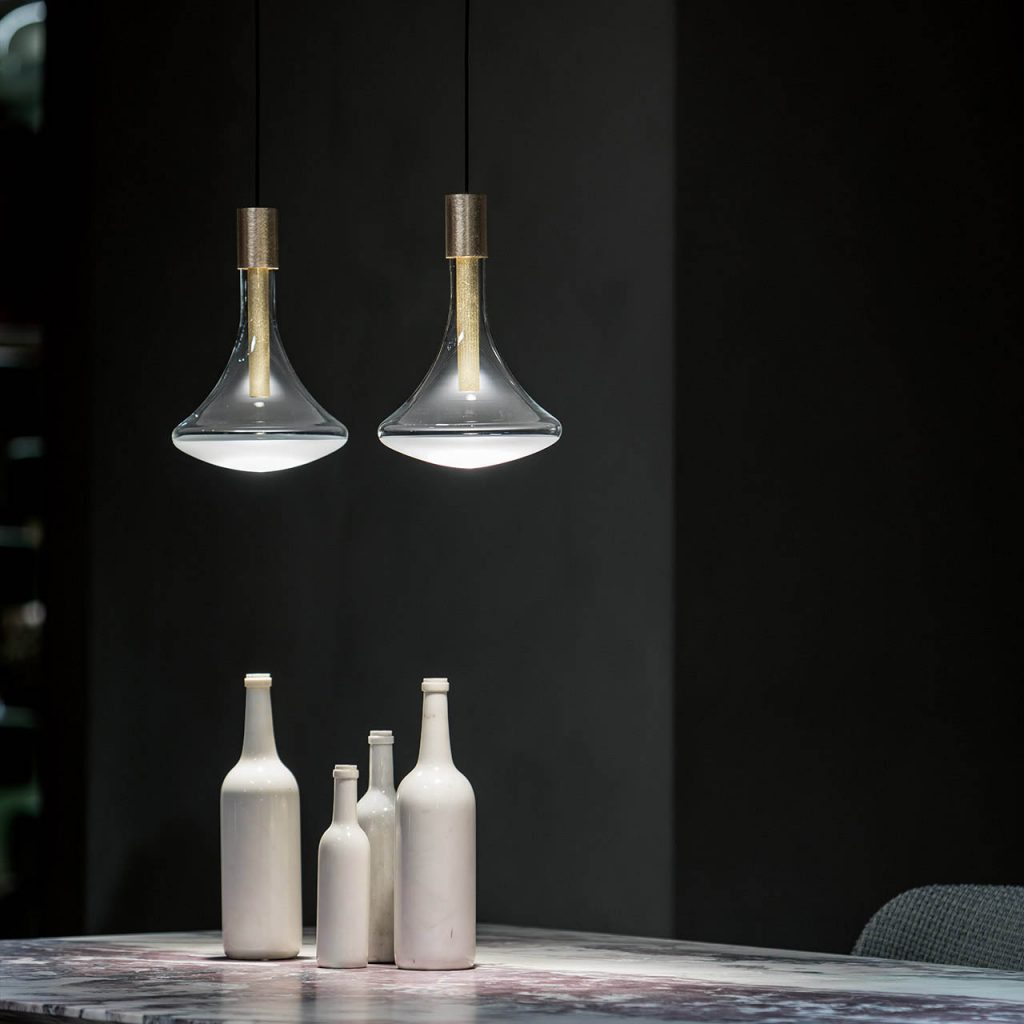 Pair of Cathode lights illuminating a table with different sized wine bottles on top