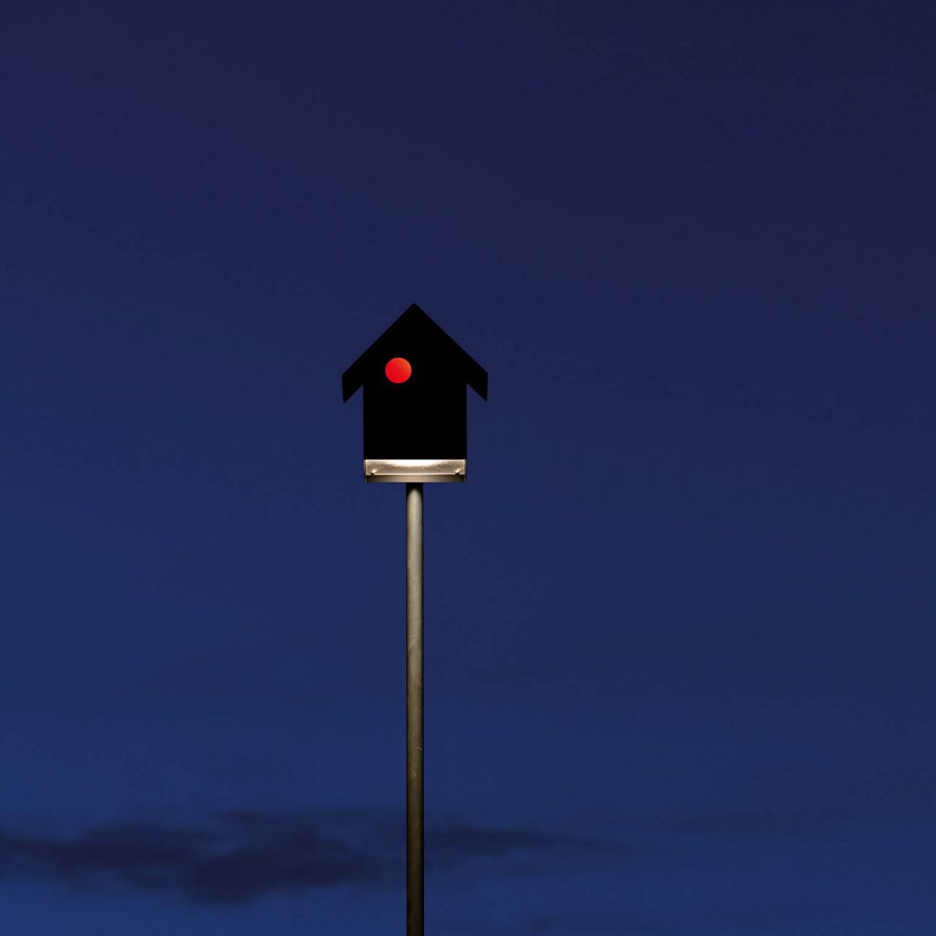 Imu light on top of a pole illuminated at dusk time
