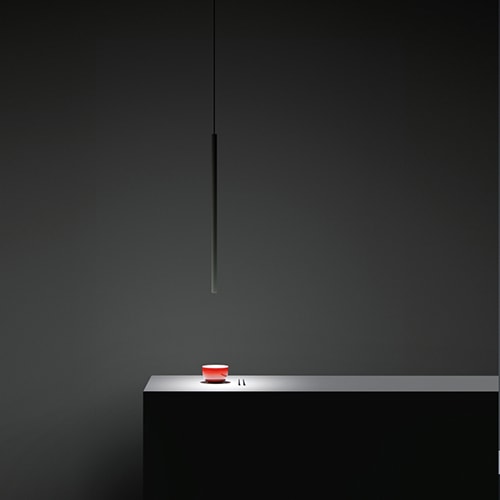 Miss suspension lamp hanging over a kitchen island in front of a grey background