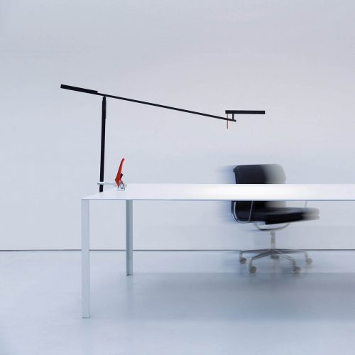 Morsetto desk lamp attached to a white desk with a black desk chair behind the desk
