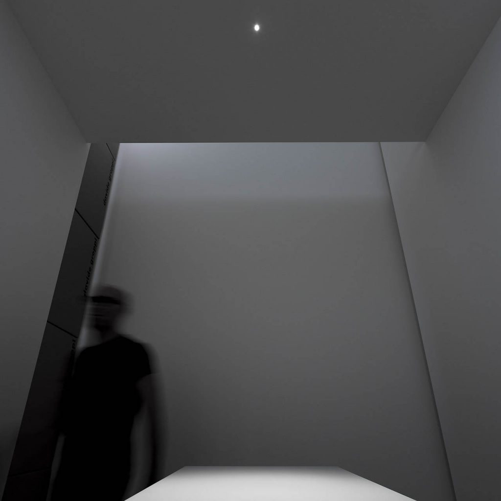 Nulla twenty five recessed lights illuminating a person in a dark grey room