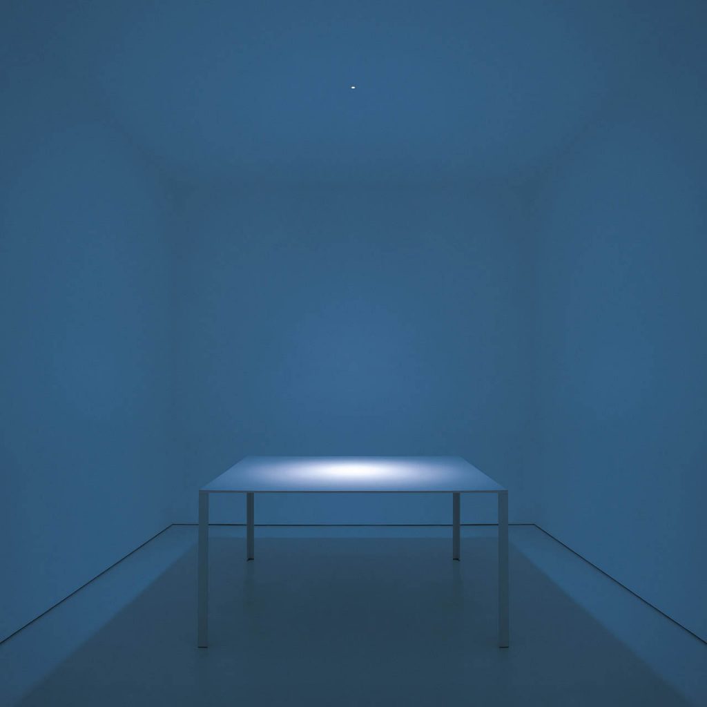 Nulla light shining on a white table in a blue room