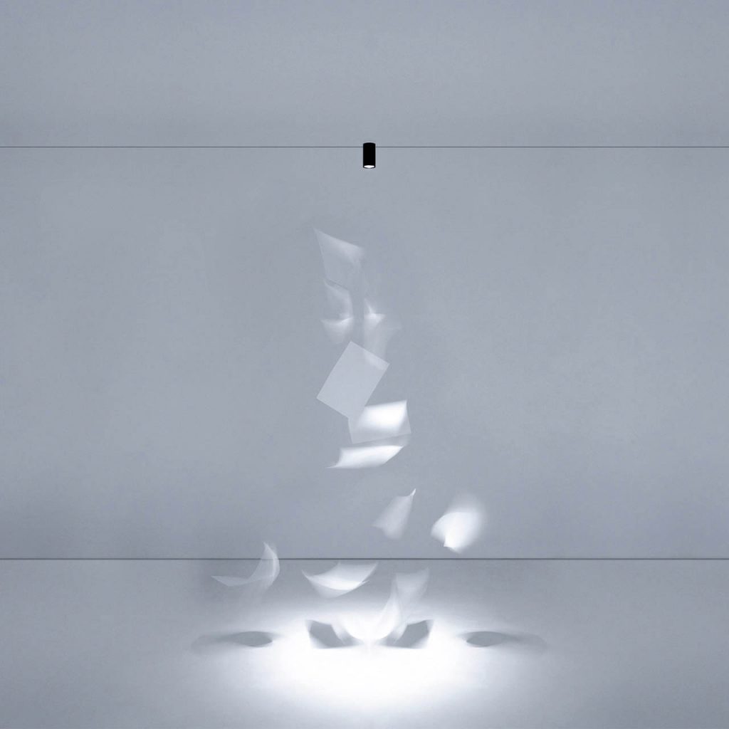 Ohm light shining over a white art piece in a white room