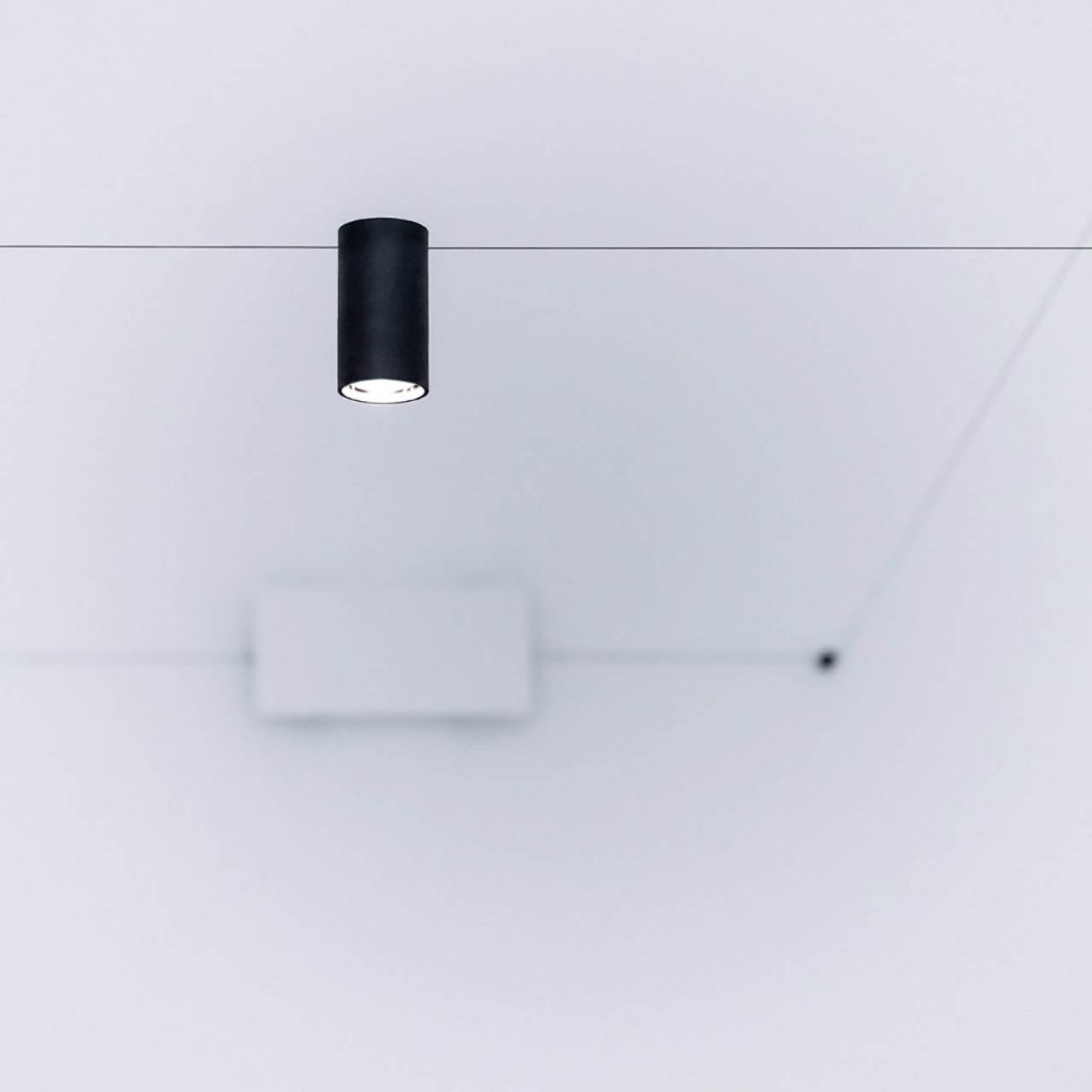 Close up of Ohm light in front of a white wall
