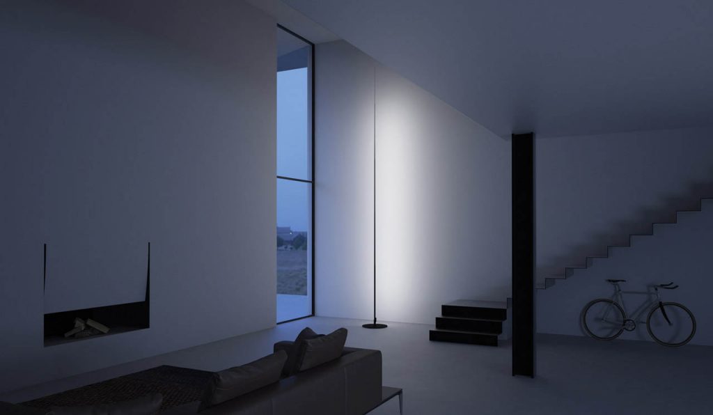 Origine light shining against a white wall with a floor to ceiling window next to the light