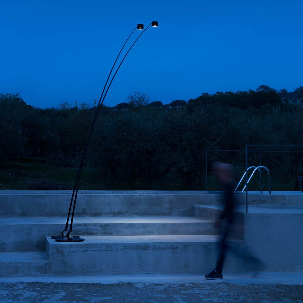 Sampei Outdoor outside at an evening time showing it illuminate the floor with a person walking in front