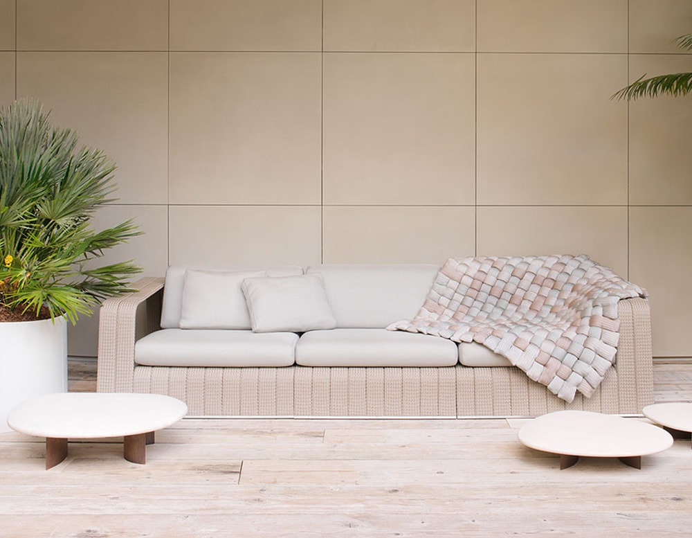 Isole table in front of a cabana sofa on top a wooden floor