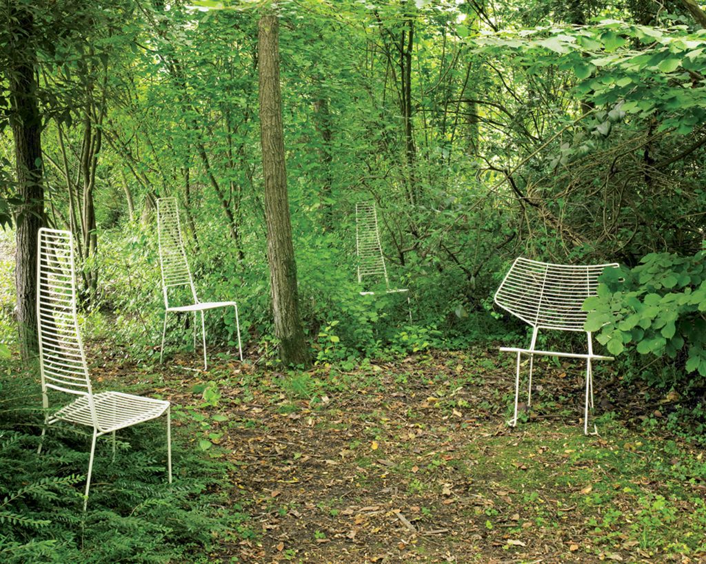 Alieno Peacock in white with both high backrest and standard backrest in a forest