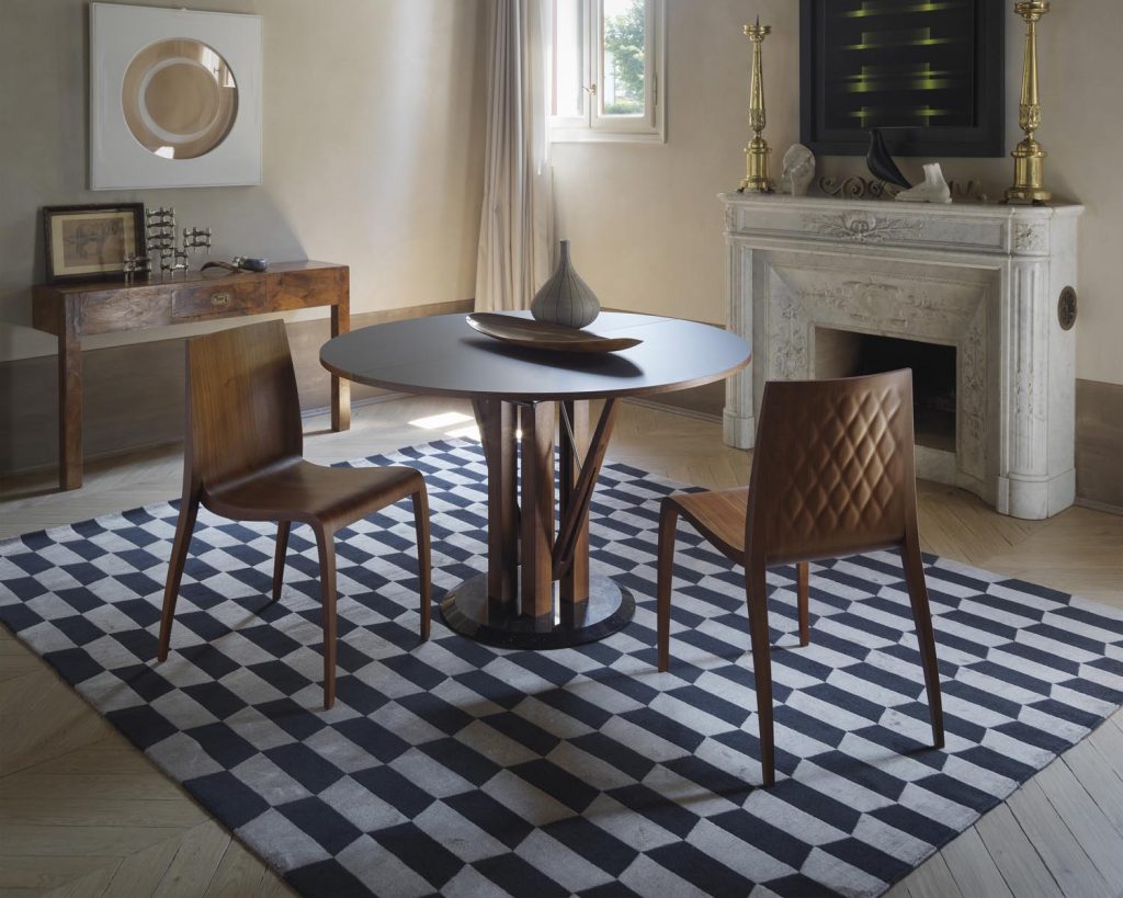 Black-topped Flower with brown chairs surrounding the table on a checkered rug