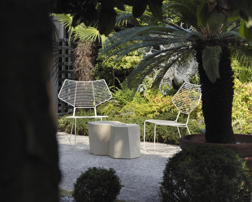 Hexagon in white color outside next to white wire chairs