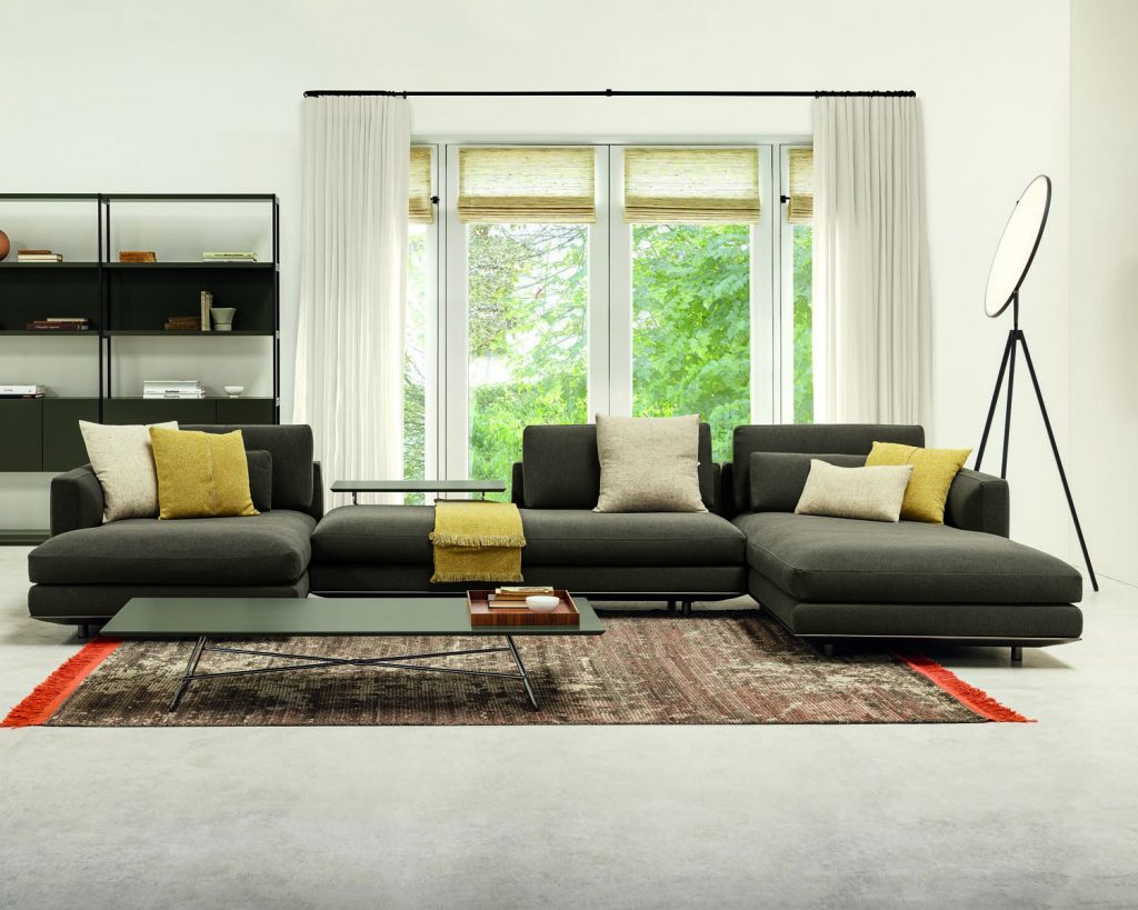 Black-colored Miles sofa on a brown rug and windows behind