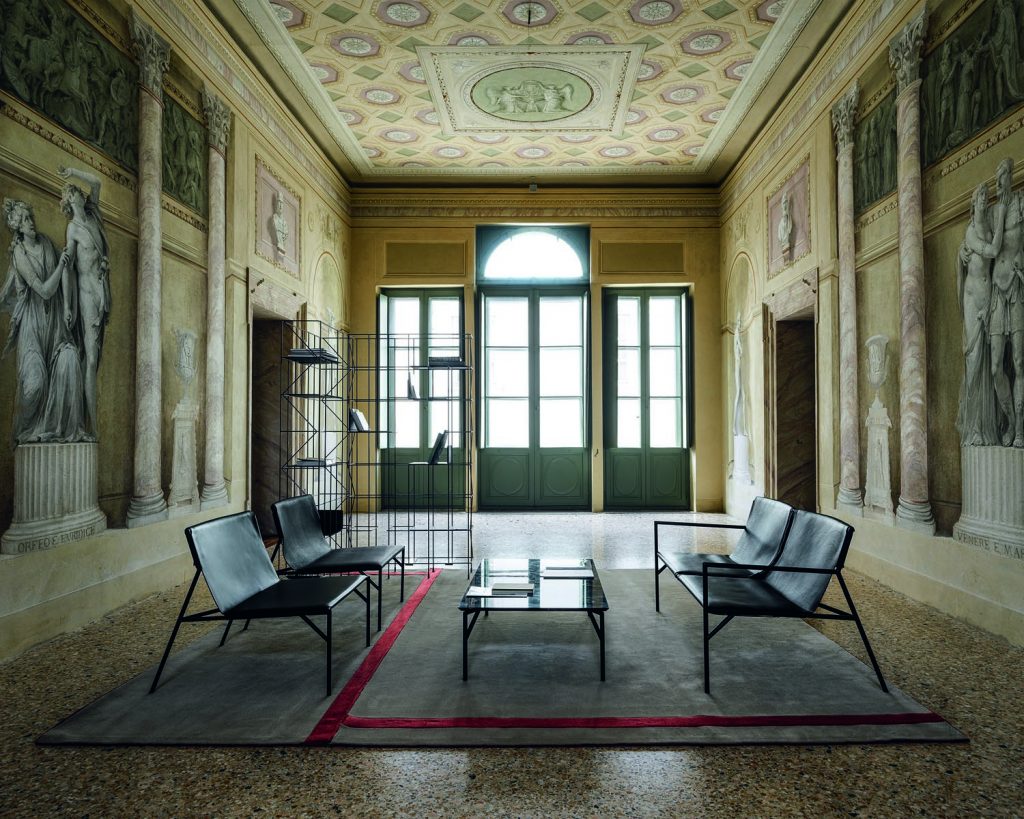 Quad Tout Le Jour facing each other with a glass table in the middle and large windows in the background