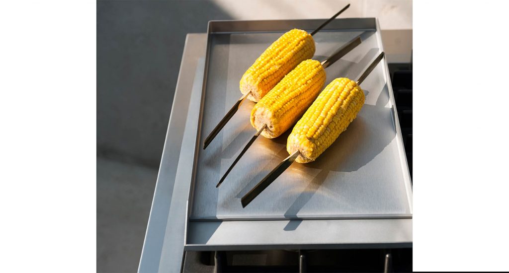Corn with skewers on top of the Norma One Cooking module