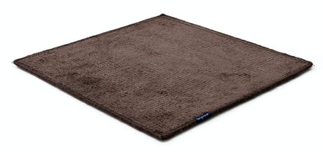 Handmade rug made of fine wool and fabrics in a dark brown tone on a white background