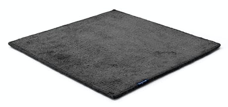 Handmade rug made of fine wool and fabrics in a dark gray tone on a white background