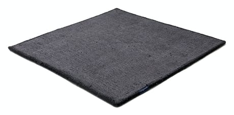 Handmade rug made of fine wool and fabrics in a dark gray tone on a white background