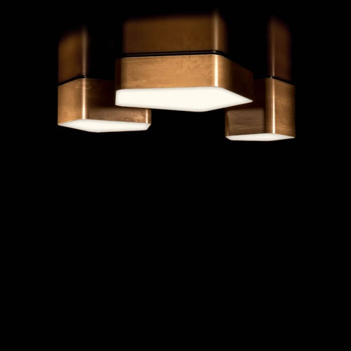 Bat Light LED ceiling lamp with pentagon shapes finished in brass on a black background.