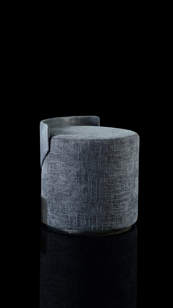 Gelly Pouf upholstered in gray leather and a base in black steel on a black background.