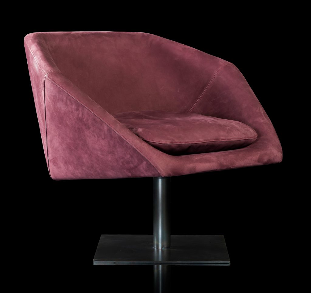 Hexagon Armchair upholstered in pink leather and brass finished central leg on a black background.