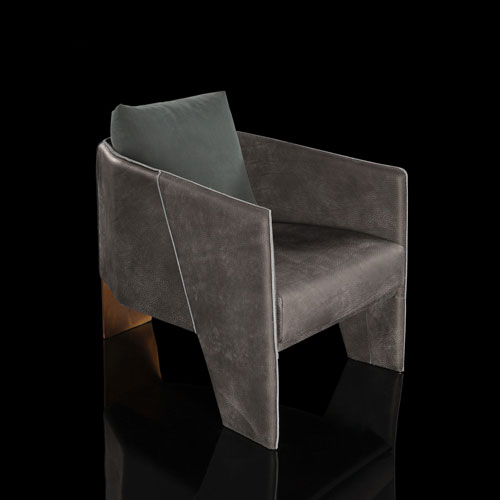 Ketch Armchair. Back leg in brass finish. finish padded seat, back, two legs and arms in gray leather finish, back cushion in gray fabric on a black background.