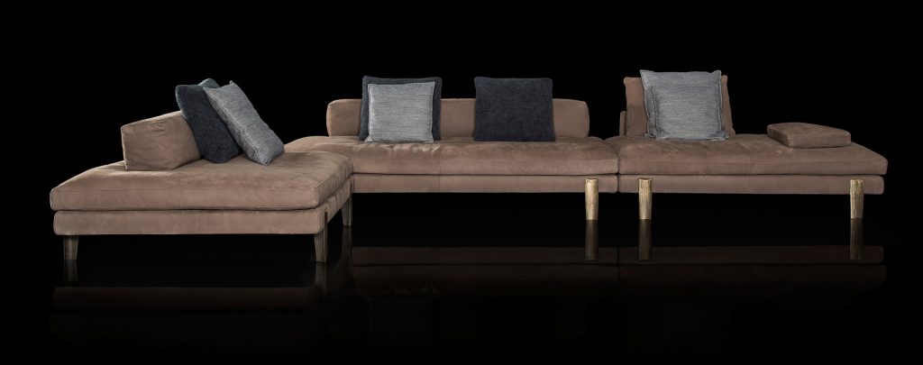 large sofa made in the shape of him upholstered in light brown velvet and base made of gold steel