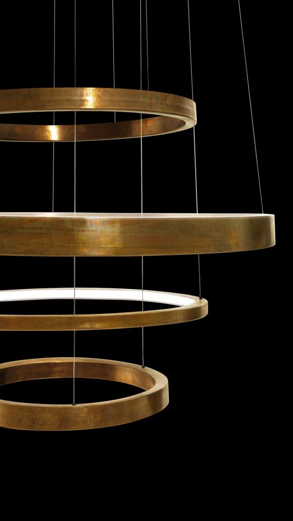 LED Pendant Light Ring made up of four brass rings using suspension wires on a black background.