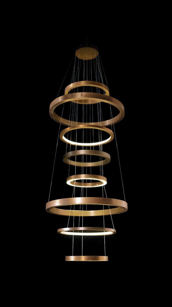 LED Pendant Light Ring made up of four brass rings using suspension wires on a black background.