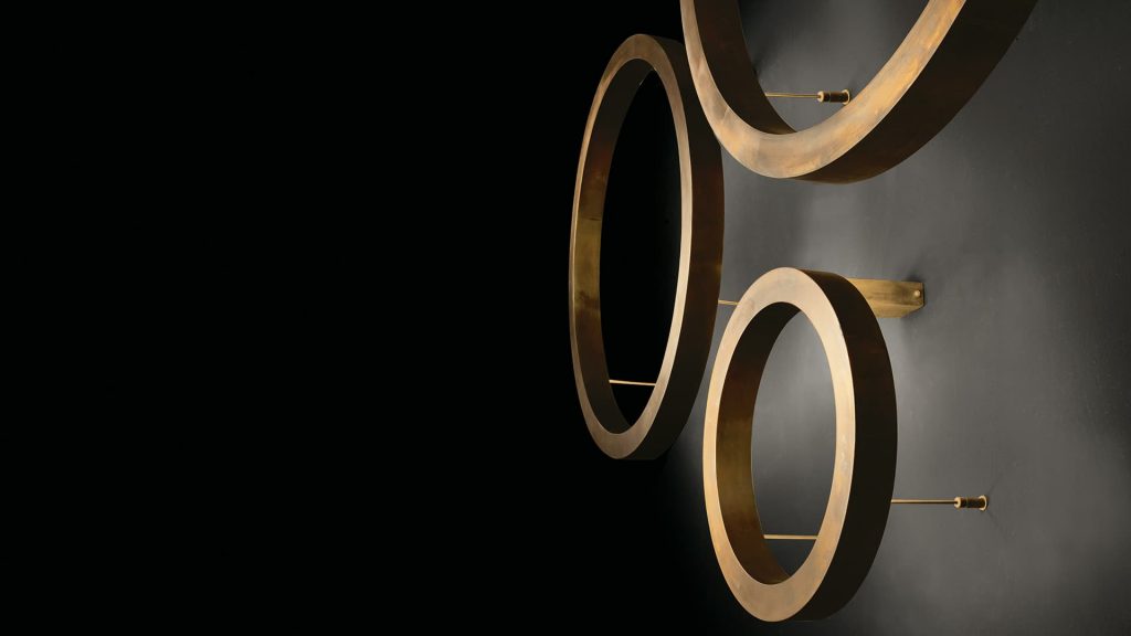 Light Ring Wall formed three rings of various sizes and types of illumination, finish silver on brass on a black background.