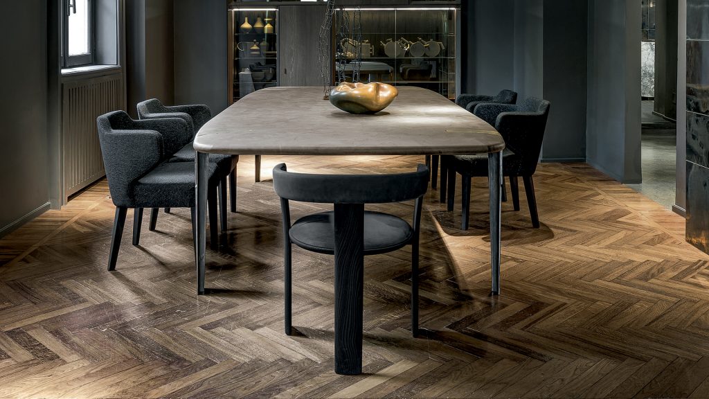 Oxymoron Table. Structure steel frame with four legs in sandcasting, bronze. Top in natural solidwood in a dining room.