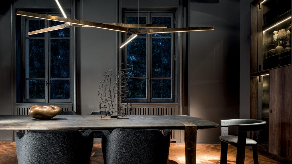 Oxymoron Table. Structure steel frame with four legs in sandcasting, bronze. Top in natural solidwood in a dining room.