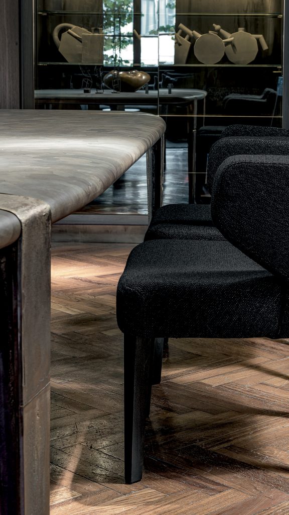 Closeup of Oxymoron Table Structure steel frame with four legs in sandcasting, bronze. Top in natural solidwood in a dining room.