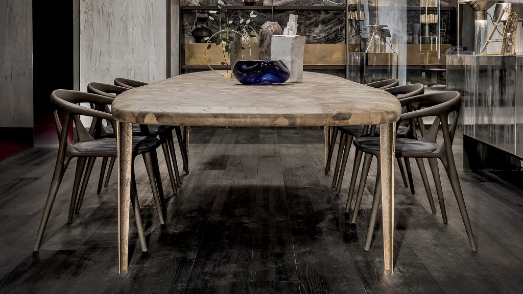 Oxymoron Table. Structure steel frame with four legs in sandcasting, bronze. Top in natural solidwood in a dining room.