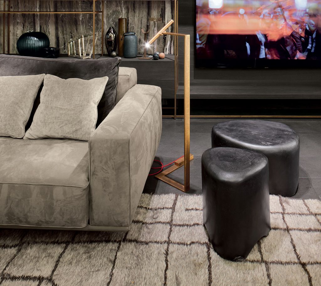 Two Pebble Tables made from black stoneware with triangle like shape in a living room.