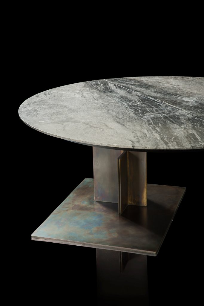 Round Shift Table Lounge. Central leg burnished black steel, top in gray and black marble on a black background.
