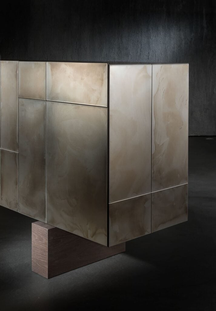 Slim Side High sideboard. Structure, base and four doors, finish in titanio on a black background.