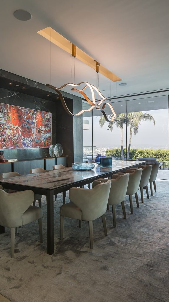 Three led Tape Light with wave shapes creating a dune like pattern using suspension cables. White light and silver structure color in a dining room.
