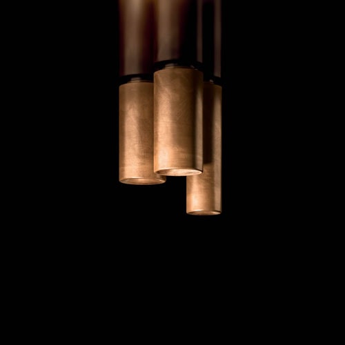 Three cylindrical ceiling Tele Lights made of burnished brass and silver on a black background.