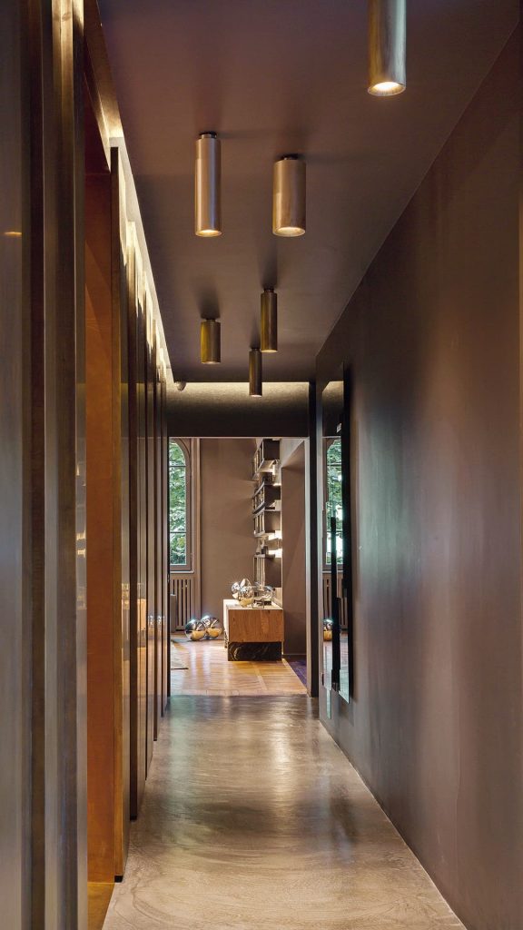 Six cylindrical ceiling Tele Lights made of burnished brass and silver in a hallway.