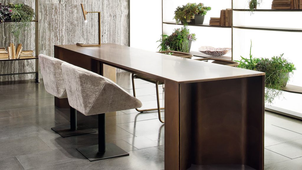 Time Table with two legs, structure in natural wood cover in burnished brass in a dining room.