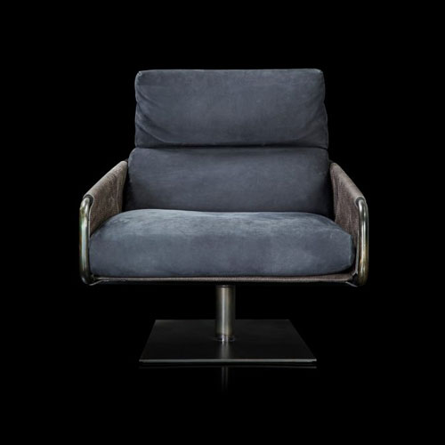 Voyage armchair, curved bronze steel structure with brown leather, gray leather cushion upholstery, central black steel leg on a black background.