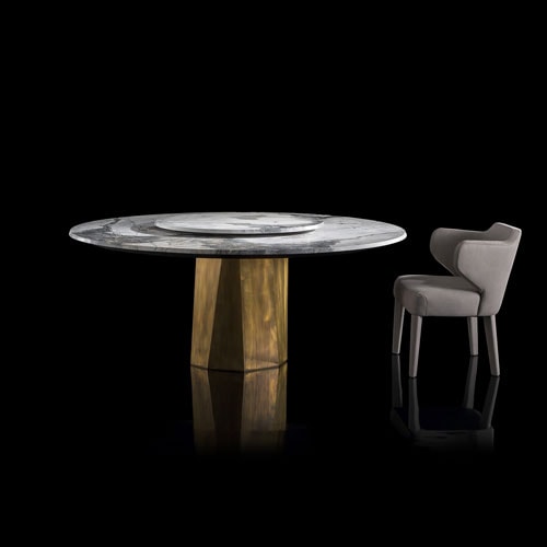 Zenith Table , white and black marble top, central leg in gold brass casing on a black background.