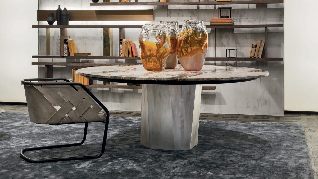 Zenith Table , white and black marble top, central leg in gold brass casing in a dining room.