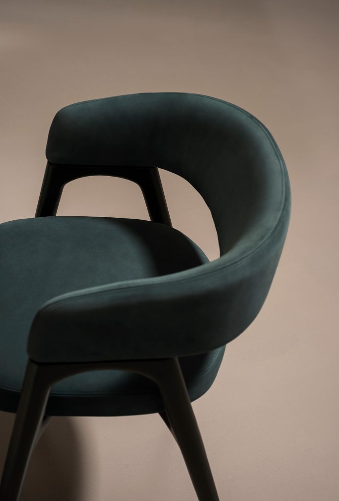 Black wooden structure chair with foam padding upholstered in green acrylic fiber