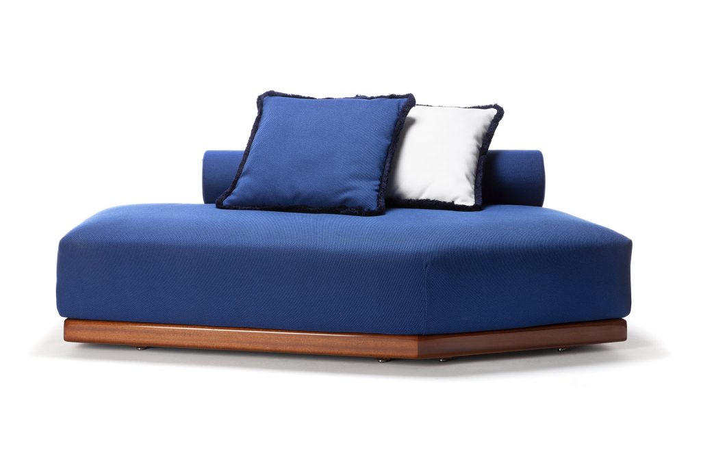blue sofa with white and blue cushions and a functional wooden base on a white background