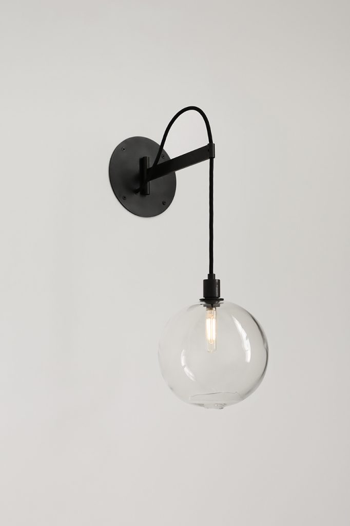 lamp with transparent glass sphere and black base on a white background.