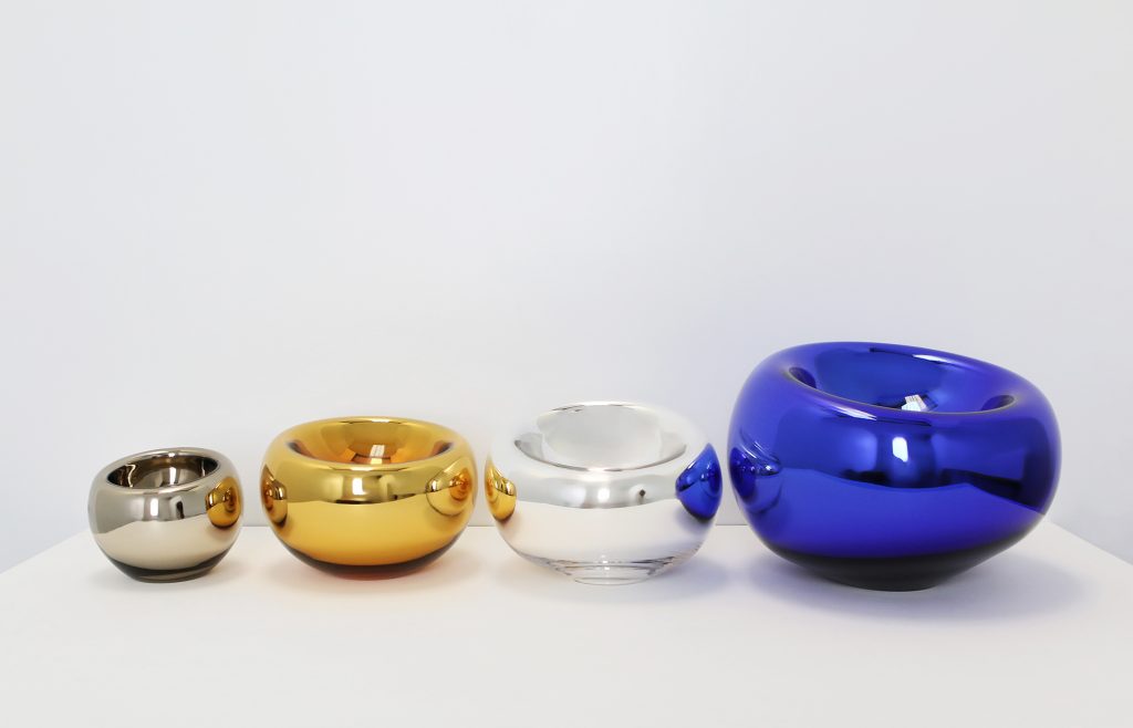 Round glass pots with a variety of colors on a white background.