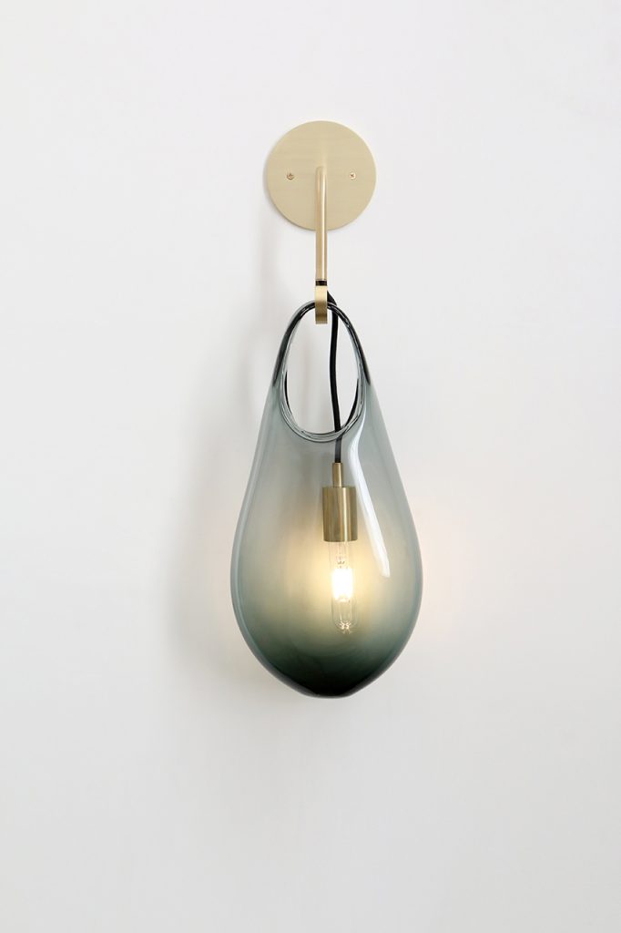 black glass vase with a gold pendant on a white background